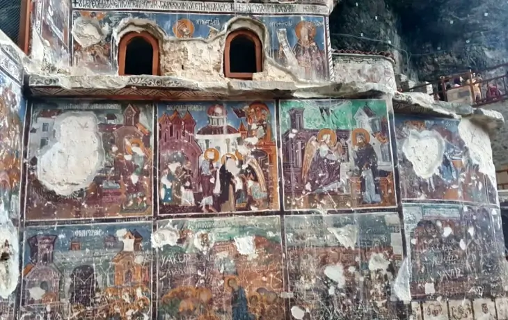 Sümela Manastırı Ana Kaya Kilisesi dış cephesindeki tahrip olmuş freskler; İsa’nın mucizeleri, havariler ve çeşitli kutsal sahneleri içeren çok panelli ikonografik düzen.